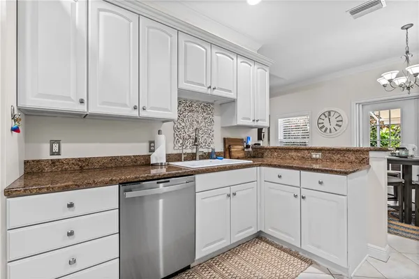 a kitchen with granite countertop white cabinets and white appliances