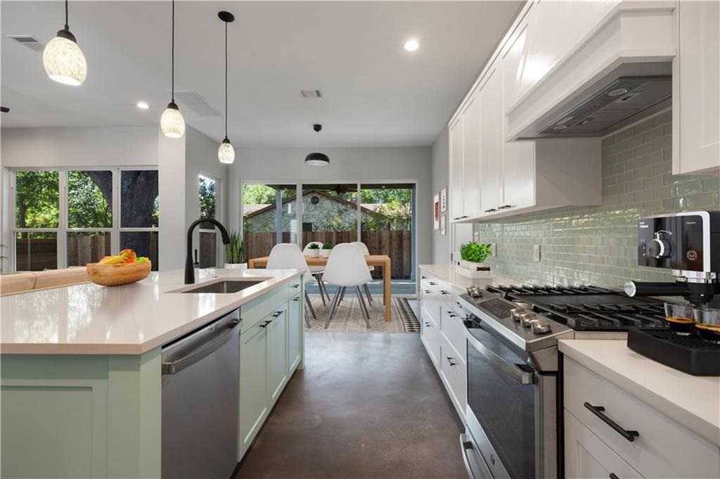 1107 Stobaugh Street, Unit 1 Austin, TX 78757 - Photo 1 of 27 a kitchen with stainless steel appliances a stove a sink a counter space a large window and white cabinets