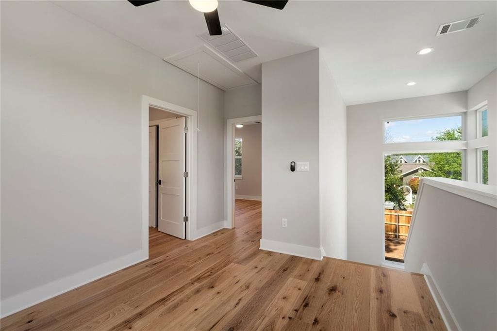 1107 Stobaugh Street, Unit 1 Austin, TX 78757 - Photo 18 of 27 an empty room with wooden floor and windows