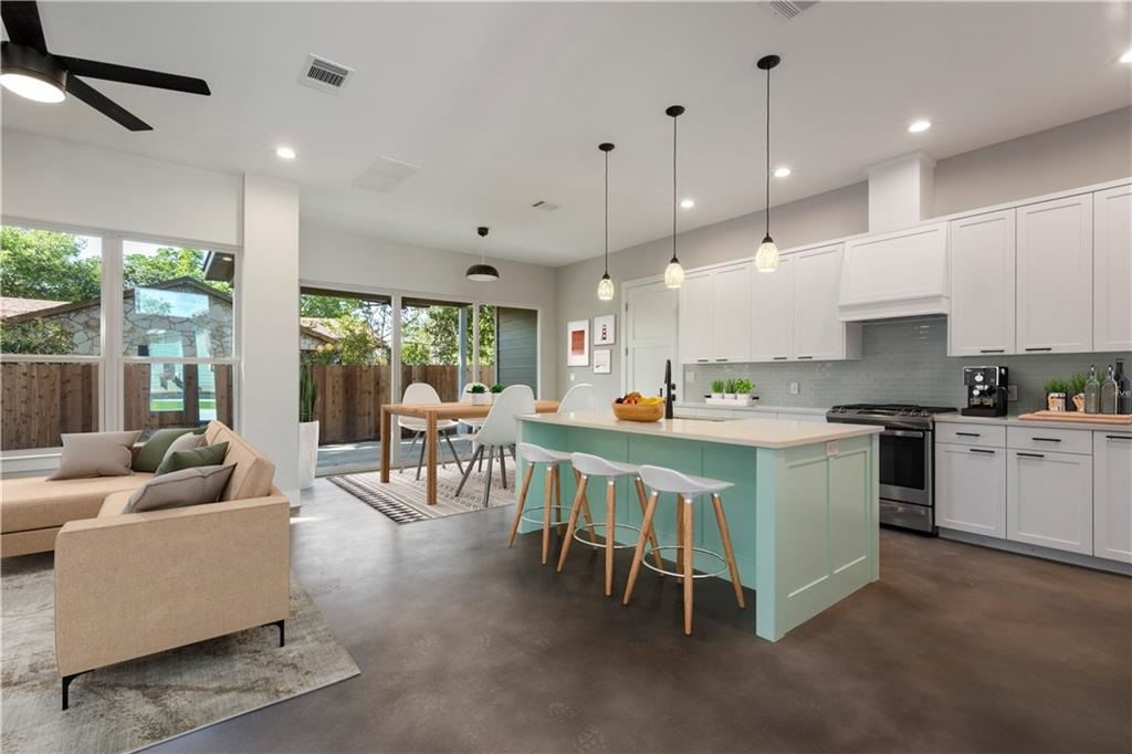 1107 Stobaugh Street, Unit 1 Austin, TX 78757 - Photo 3 of 27 a kitchen with kitchen island stainless steel appliances a table and chairs