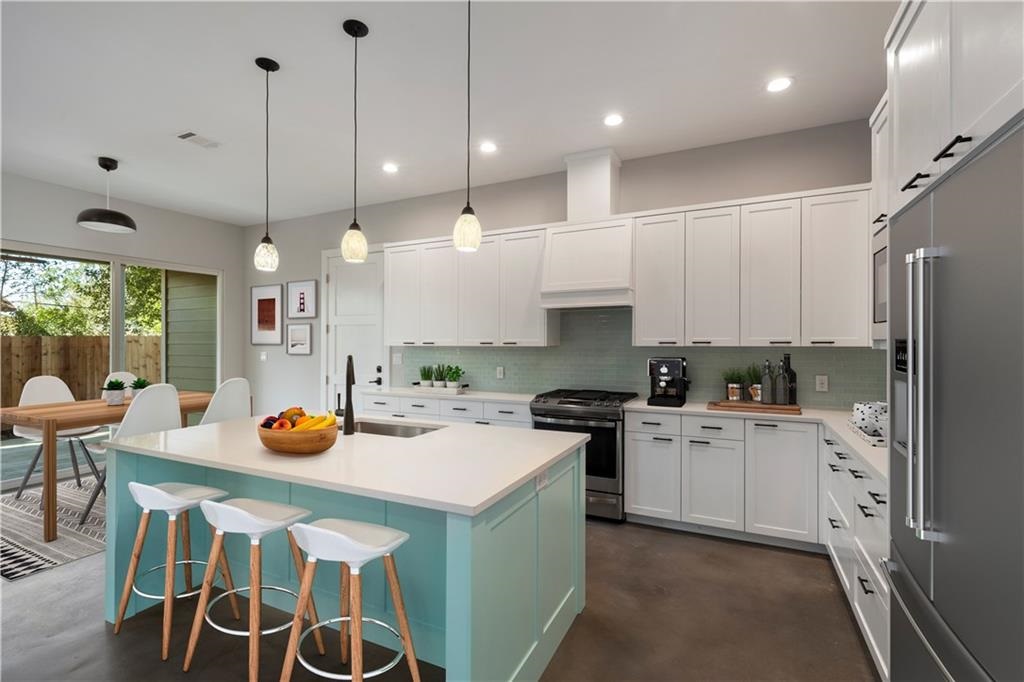 1107 Stobaugh Street, Unit 1 Austin, TX 78757 - Photo 5 of 27 a kitchen with a sink a stove a refrigerator a center island and chairs
