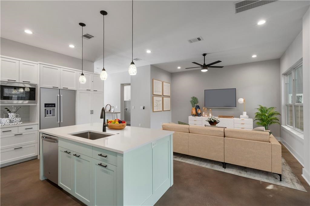 1107 Stobaugh Street, Unit 1 Austin, TX 78757 - Photo 26 of 27 a large white kitchen with cabinets a sink a window and stainless steel appliances