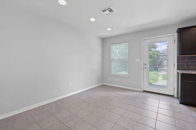 an empty room with windows and fireplace