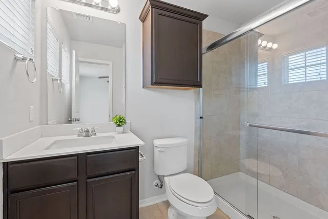 a bathroom with a sink a toilet and shower