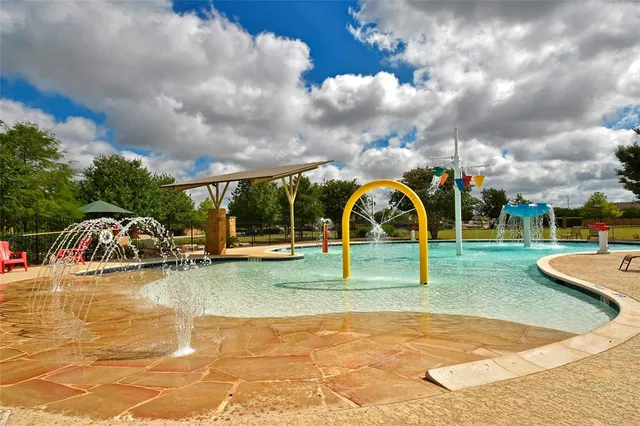 a view of swimming pool with playground and green space