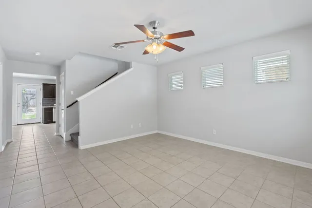 an empty room with windows and fan