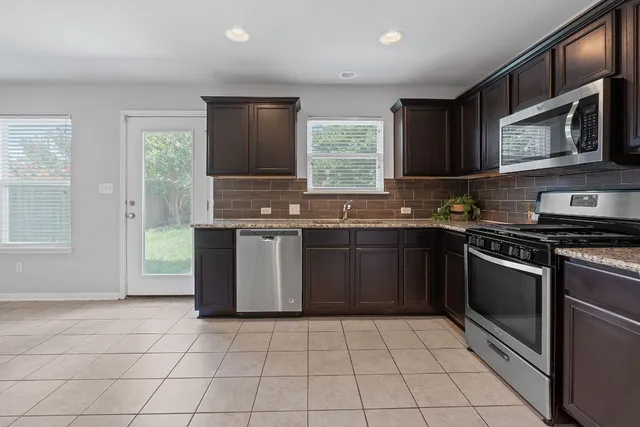 a kitchen with a sink stove top oven and microwave