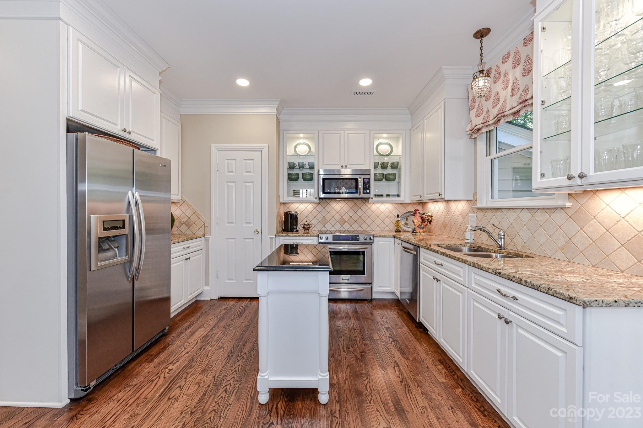 130 Morrison Hill Road Davidson, NC 28036 - Photo 8 of 29 a kitchen with stainless steel appliances granite countertop a refrigerator a stove a sink and white cabinets with wooden floor