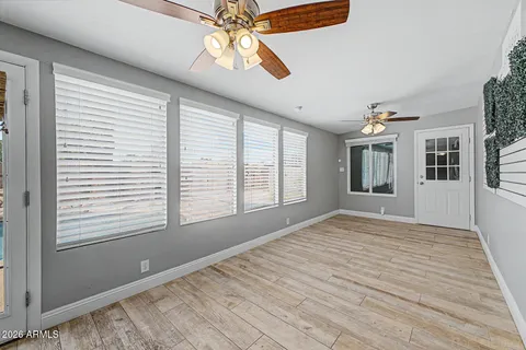 a view of an empty room with a window and wooden floor