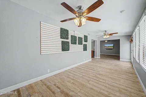 an empty room with windows and ceiling fan