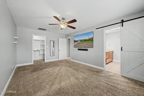 a view of empty room with wooden floor and ceiling fan