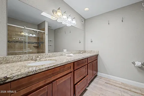 a bathroom with a granite countertop sink and a large mirror