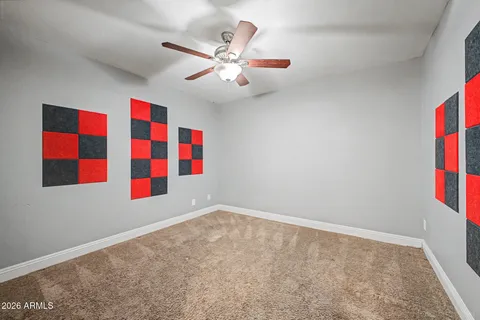 an empty room with windows and ceiling fan