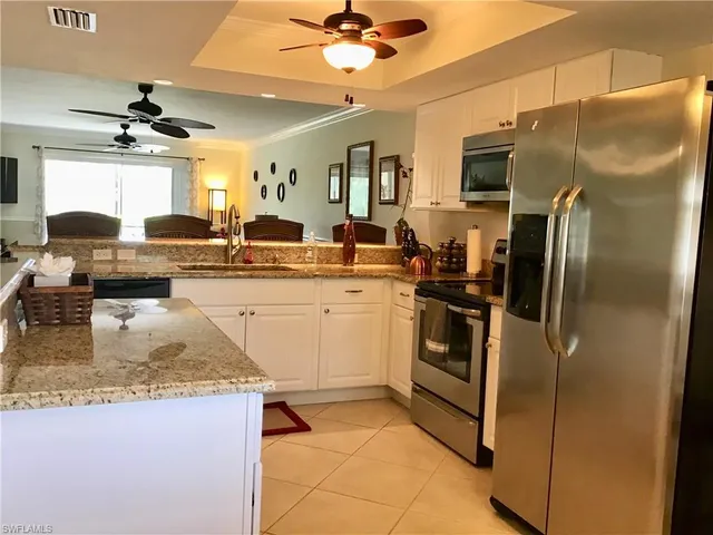 a kitchen with stainless steel appliances granite countertop a sink a stove and refrigerator