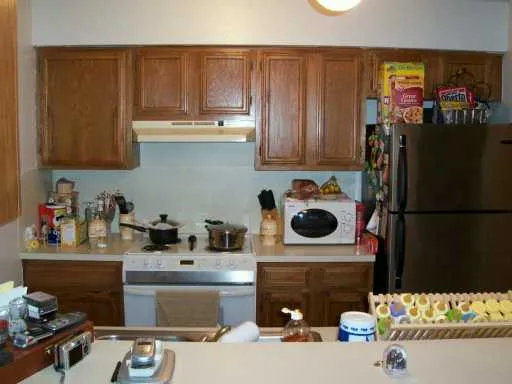 a kitchen with a refrigerator and a stove top oven