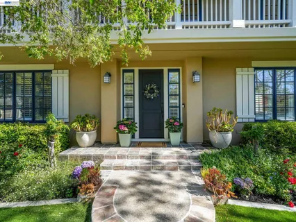 a front view of a house with a yard and potted plants