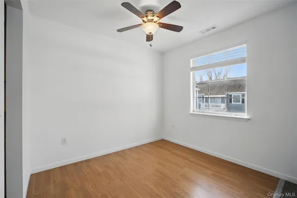 an empty room with a window and a fan