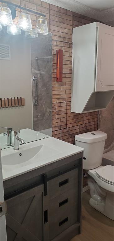 5532 Boca Raton Boulevard, Unit 290 Fort Worth, TX 76112 - Photo 4 of 16 Bathroom vanity featuring a white rectangular sink, chrome faucet, and gray wood-finish cabinetry with barn door-style paneling.