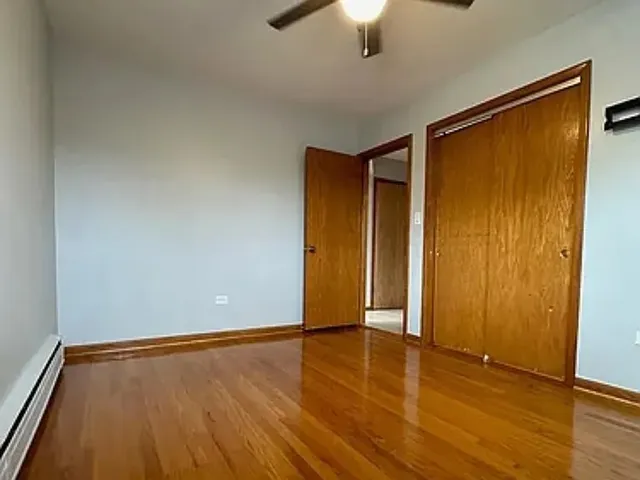 an empty room with wooden floor and closet