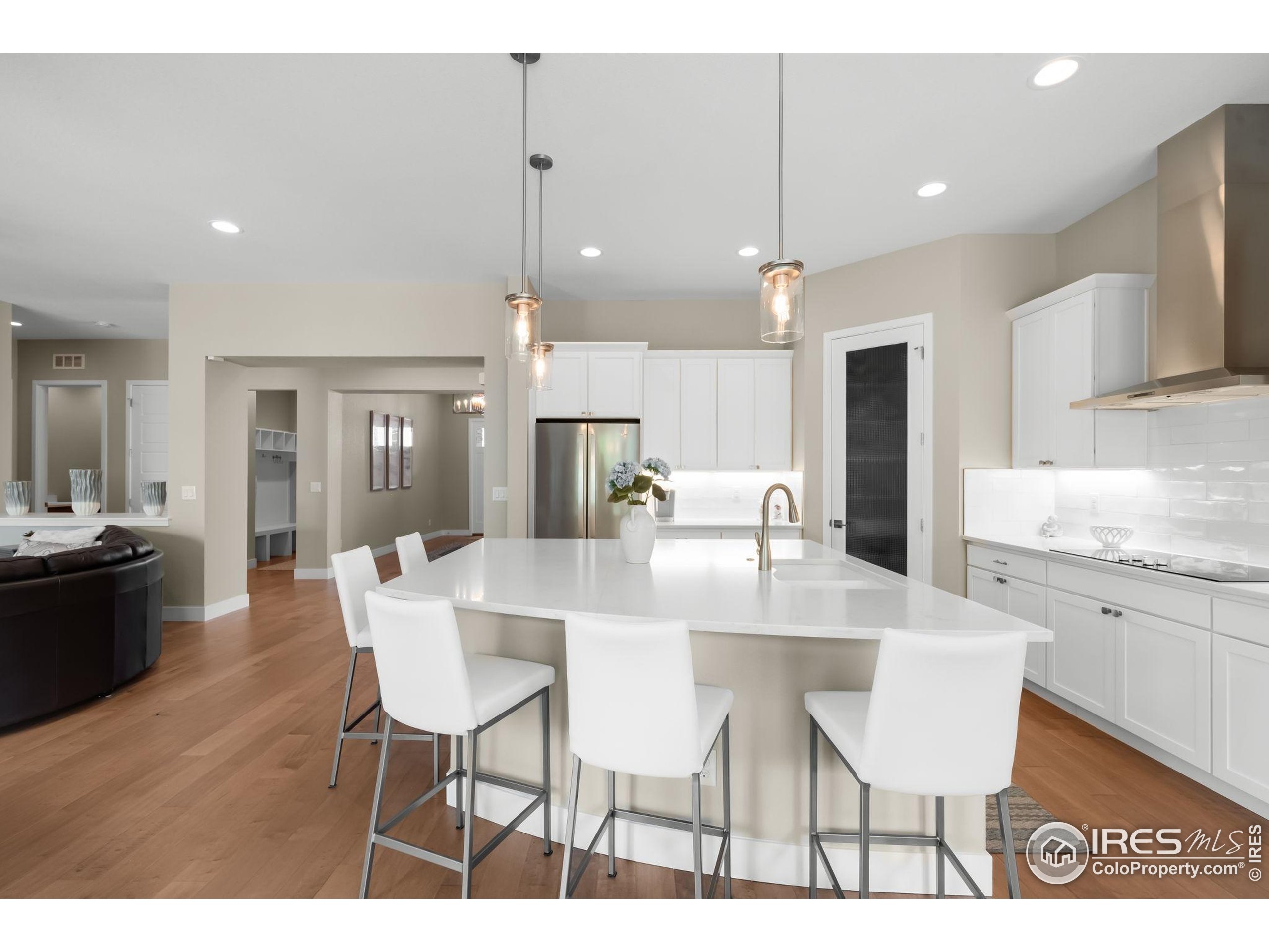 5799 Howell Street Golden, CO 80403 - Photo 12 of 50 a view of a dining room and livingroom with furniture wooden floor a rug a chandelier