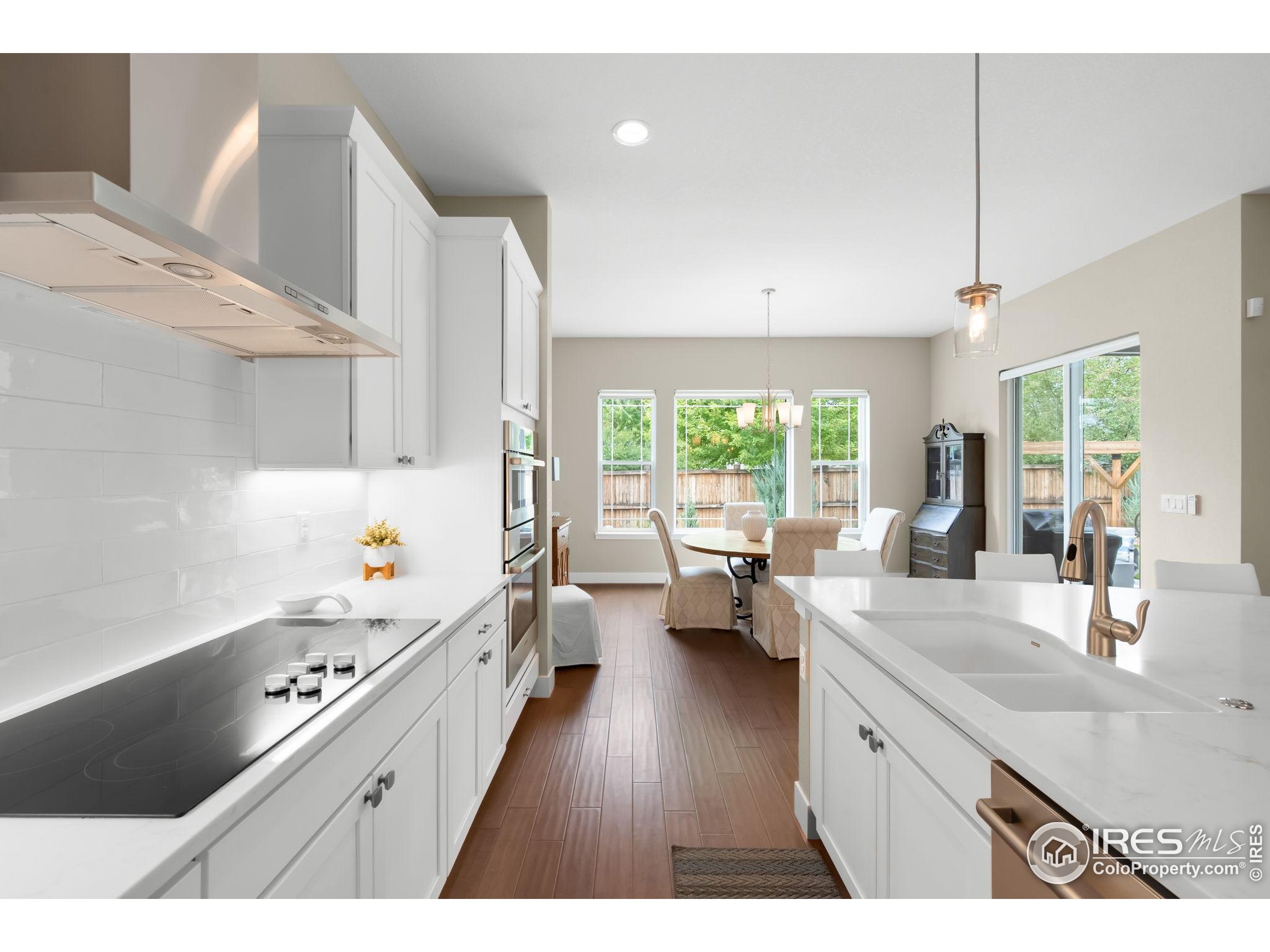 5799 Howell Street Golden, CO 80403 - Photo 10 of 50 a kitchen that has a lot of cabinets a sink and wooden floor