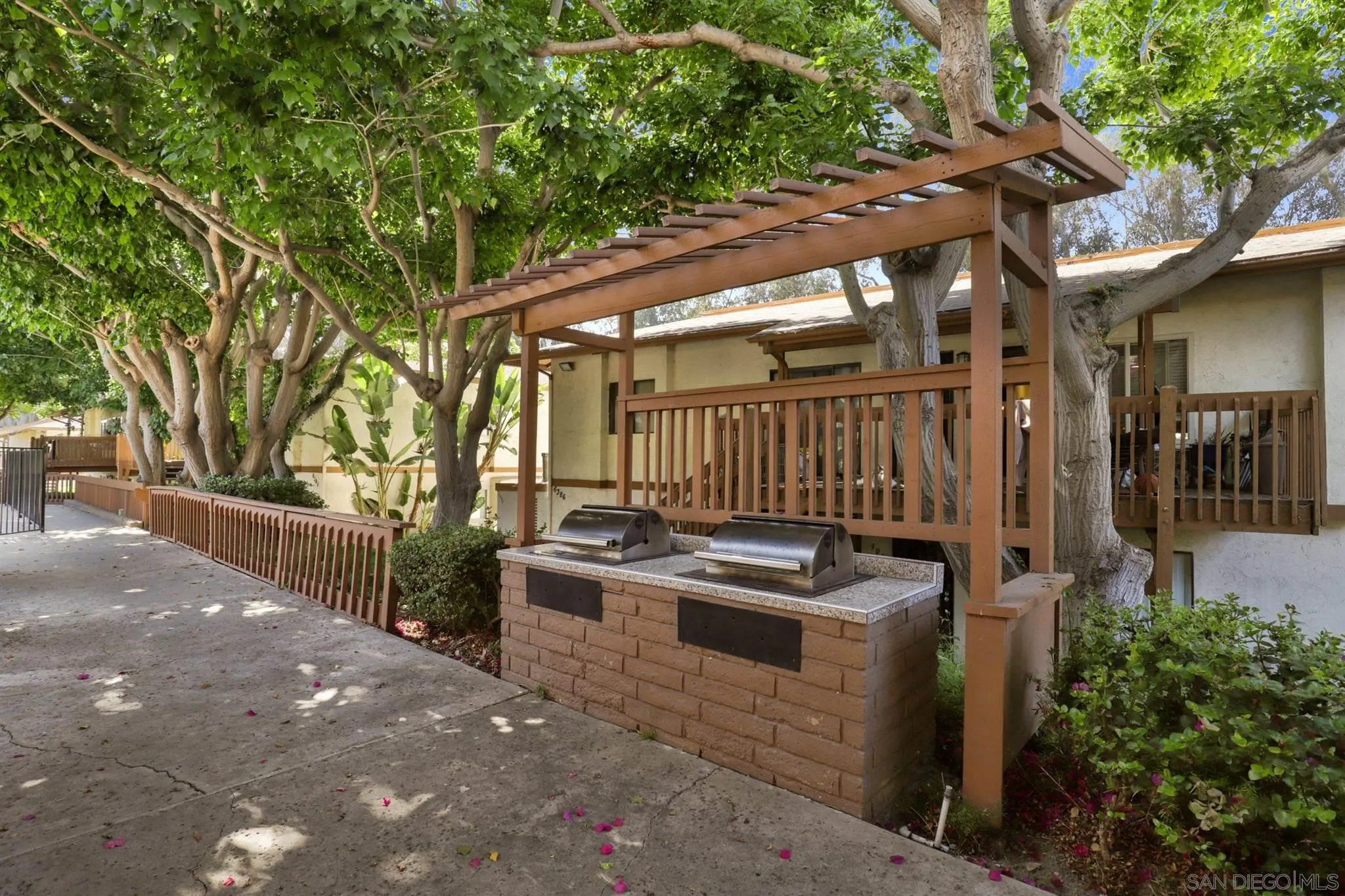 6370 Rancho Mission Road, Unit 920 San Diego, CA 92108 - Photo 17 of 22 a backyard of a house with barbeque oven and outdoor seating
