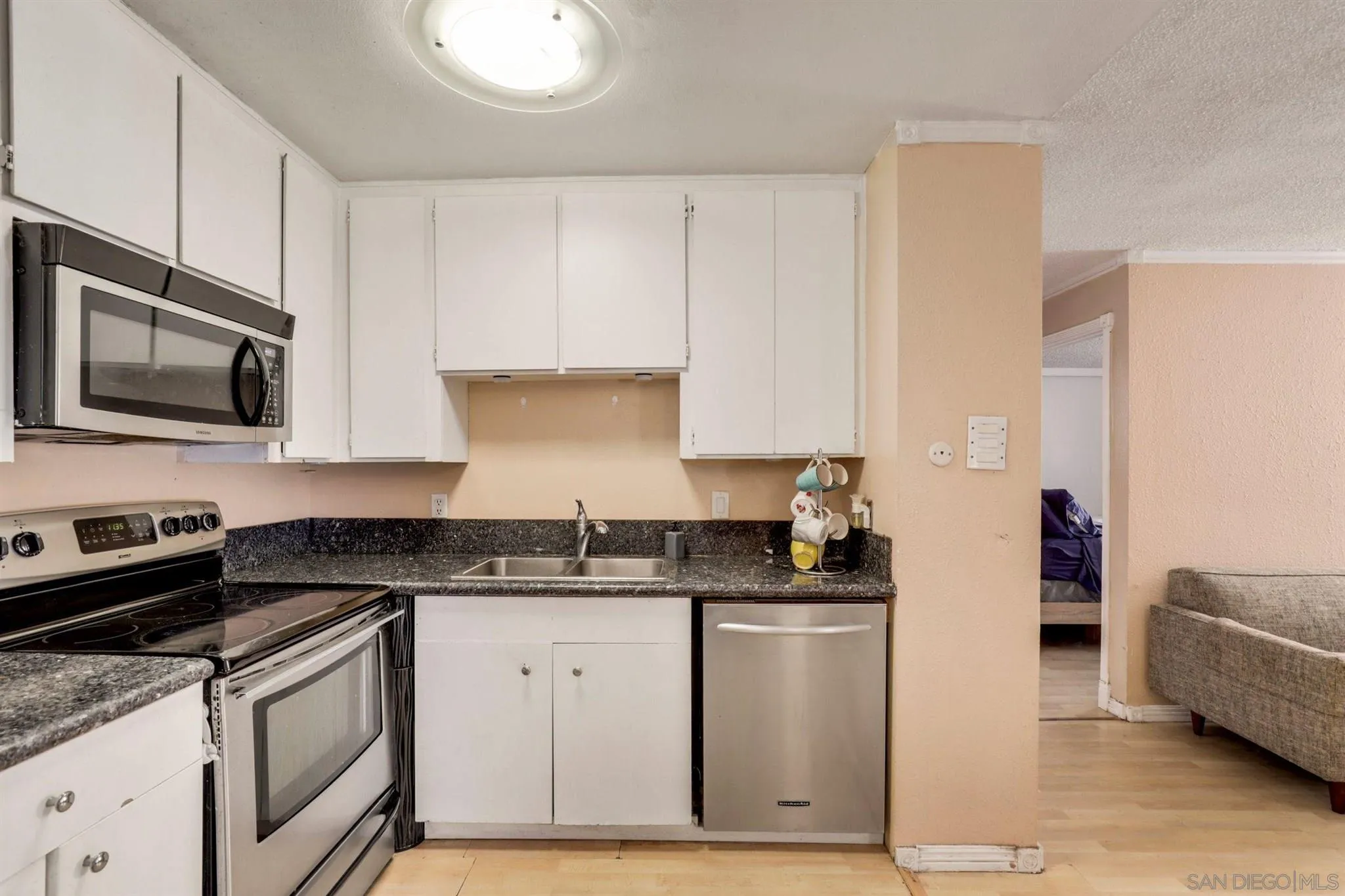 6370 Rancho Mission Road, Unit 920 San Diego, CA 92108 - Photo 6 of 22 a kitchen with granite countertop a sink a stove and cabinets