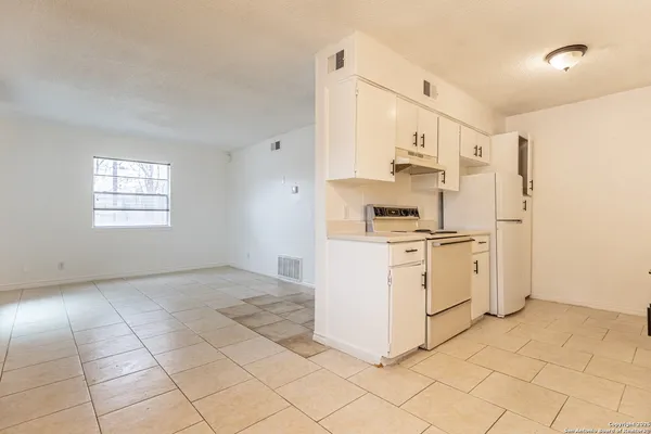 a kitchen with white cabinets and white appliances
