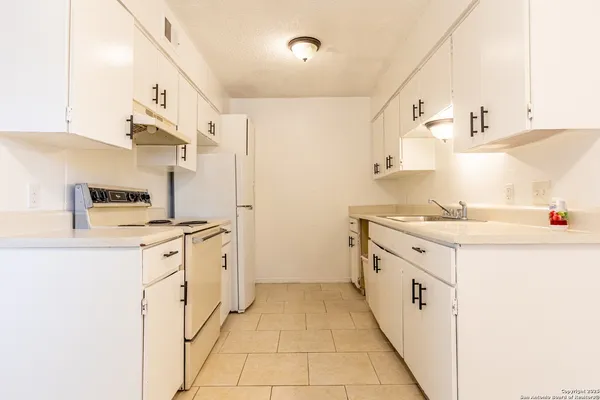 a kitchen with granite countertop a sink and a stove top oven