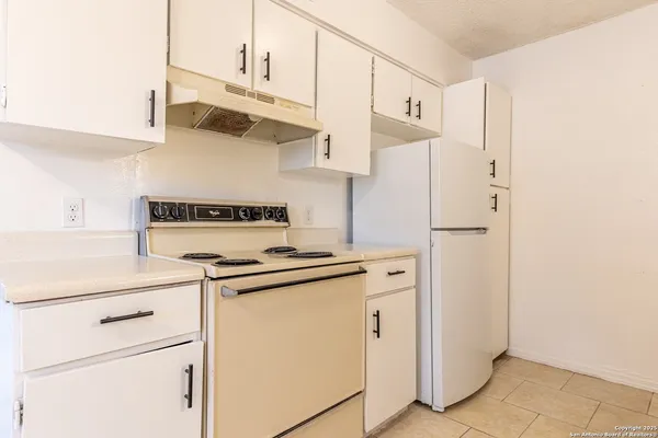 a kitchen with stainless steel appliances white cabinets and a refrigerator