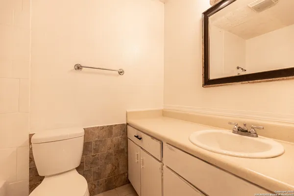 a bathroom with a toilet sink and mirror