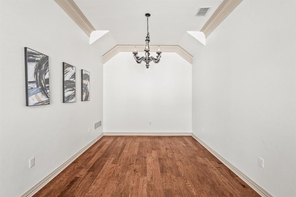 6393 Burnham Street Frisco, TX 75034 - Photo 11 of 30 a view of a hallway with wooden floor and a chandelier