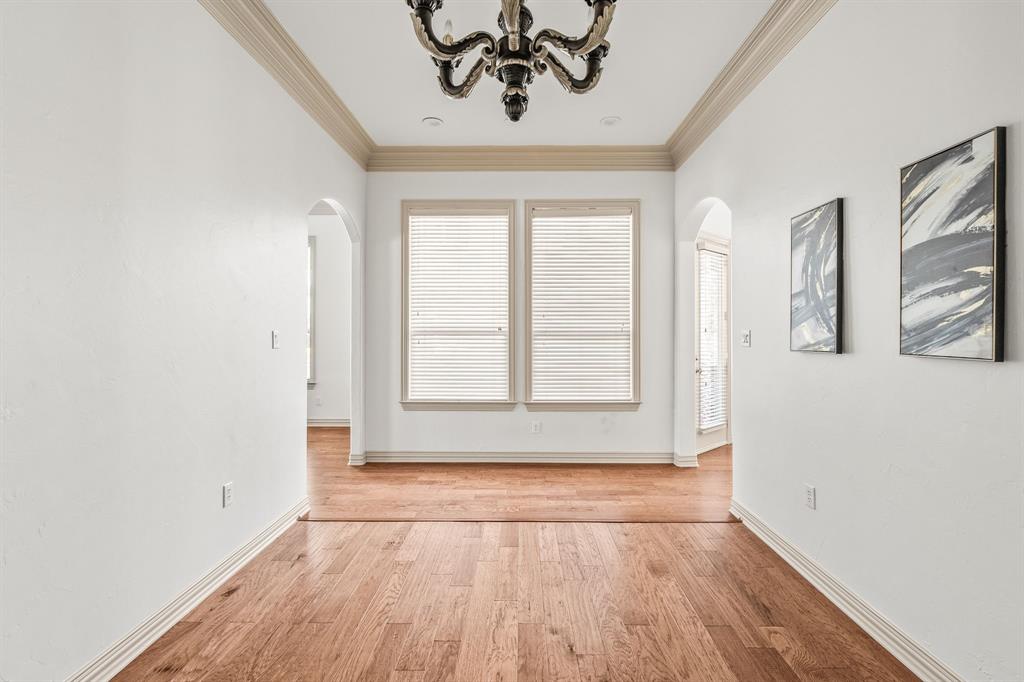 6393 Burnham Street Frisco, TX 75034 - Photo 12 of 30 an empty room with wooden floor chandelier and windows