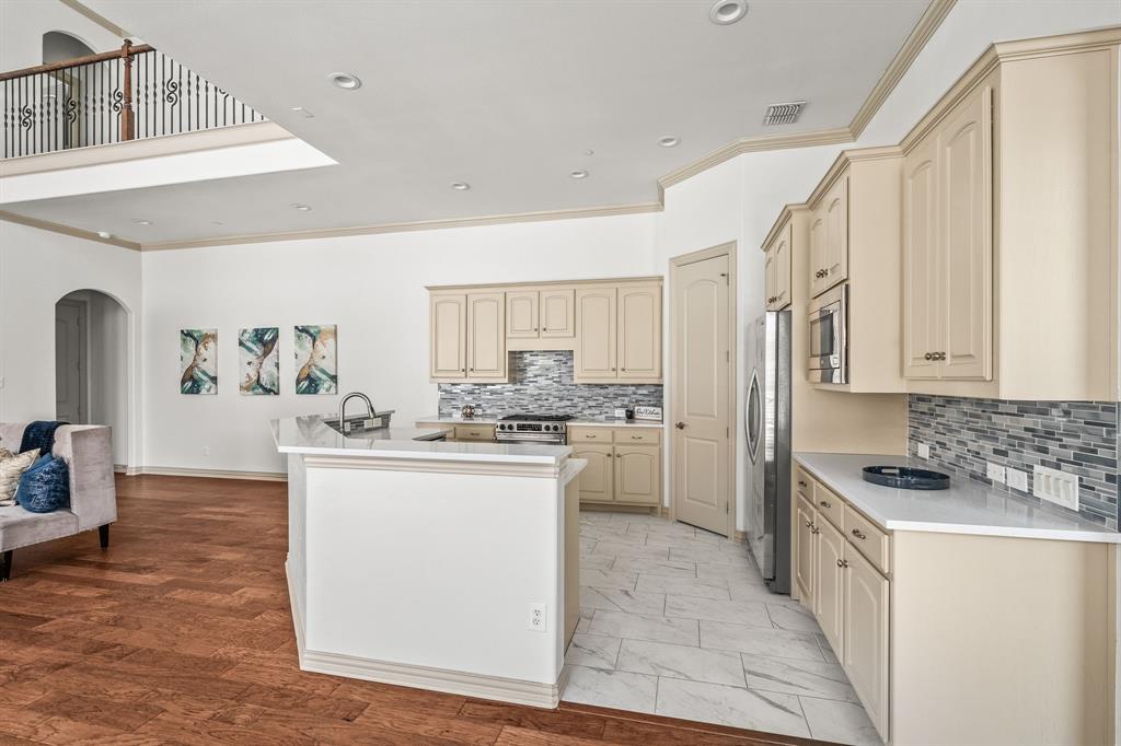 6393 Burnham Street Frisco, TX 75034 - Photo 14 of 30 a kitchen with cabinets and wooden floor