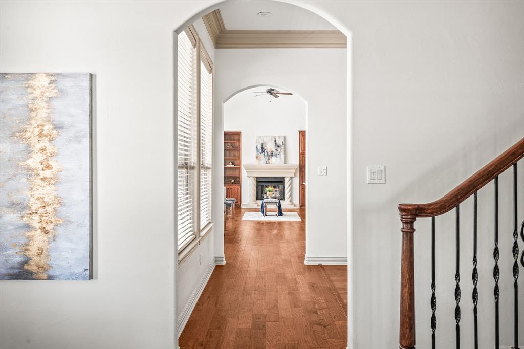 6393 Burnham Street Frisco, TX 75034 - Photo 7 of 30 a view of a hallway with wooden floor and a living room