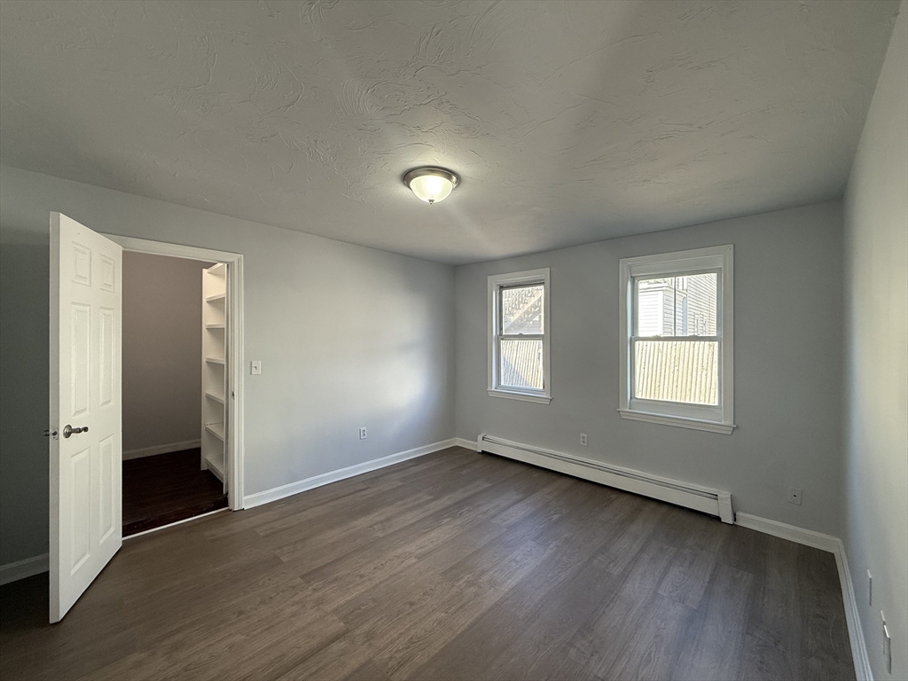 30 Sanger Street, Unit 1 Framingham, MA 01702 - Photo 11 of 15 an empty room with wooden floor and windows