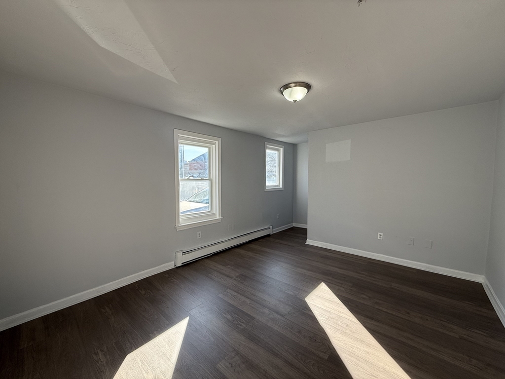 30 Sanger Street, Unit 1 Framingham, MA 01702 - Photo 13 of 15 a view of an empty room with wooden floor and a window
