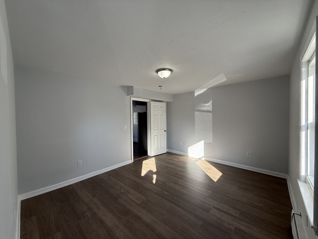 30 Sanger Street, Unit 1 Framingham, MA 01702 - Photo 14 of 15 a view of an empty room with wooden floor and a window
