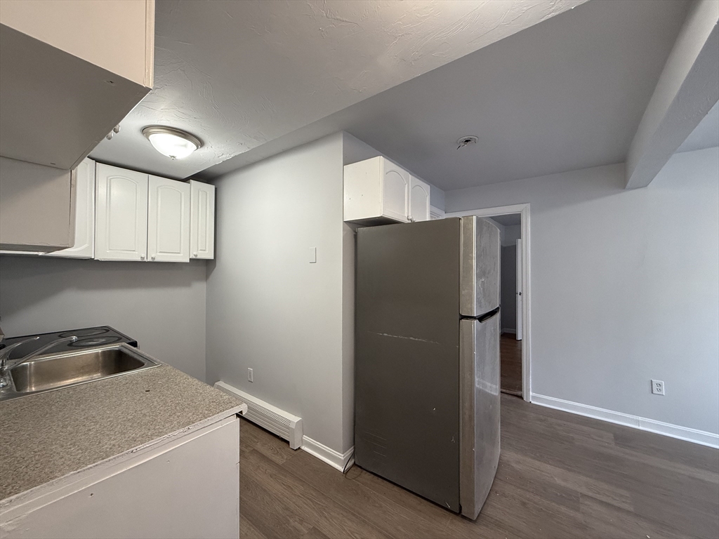 30 Sanger Street, Unit 1 Framingham, MA 01702 - Photo 5 of 15 a view of a kitchen with a fridge and wooden floor