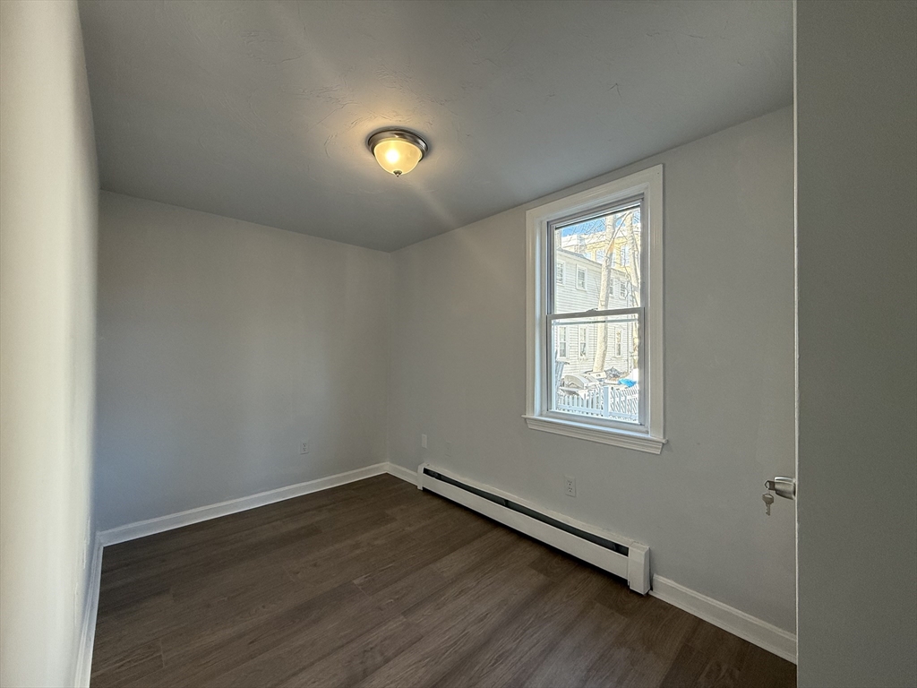 30 Sanger Street, Unit 1 Framingham, MA 01702 - Photo 7 of 15 an empty room with wooden floor and windows