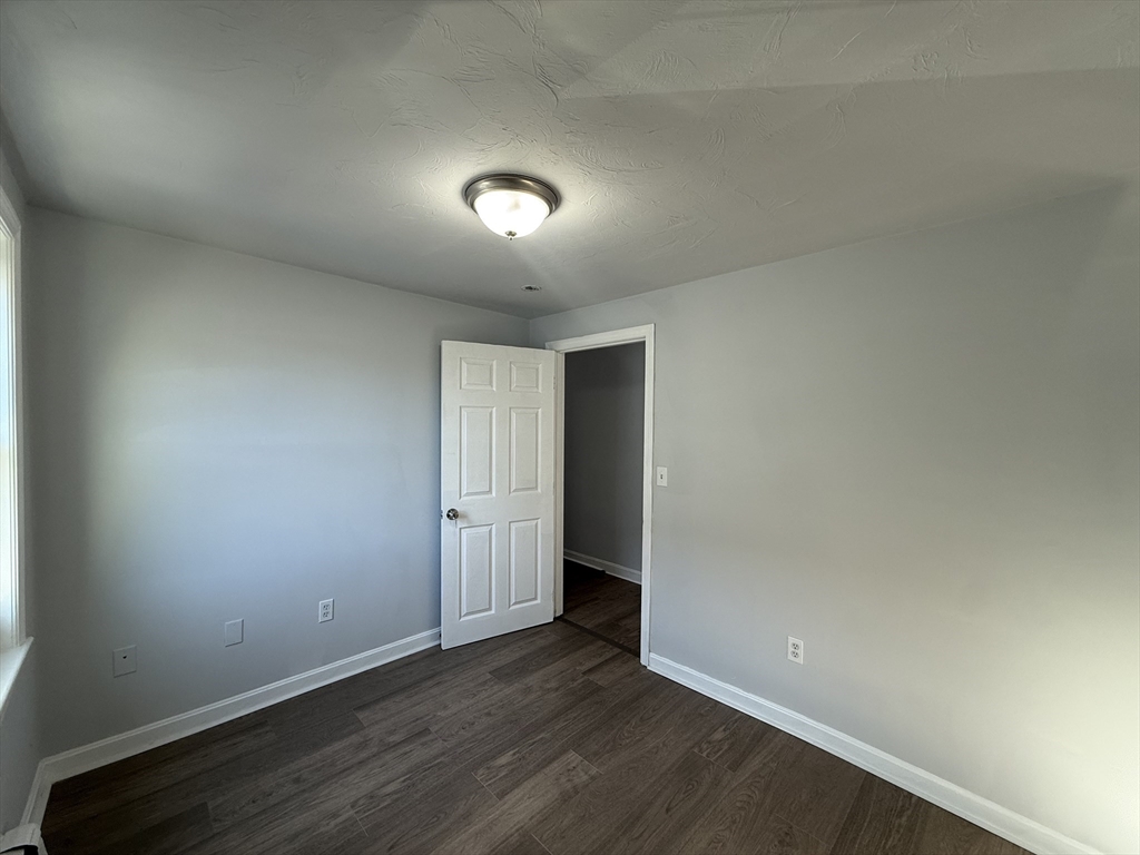 30 Sanger Street, Unit 1 Framingham, MA 01702 - Photo 10 of 15 an empty room with wooden floor and windows