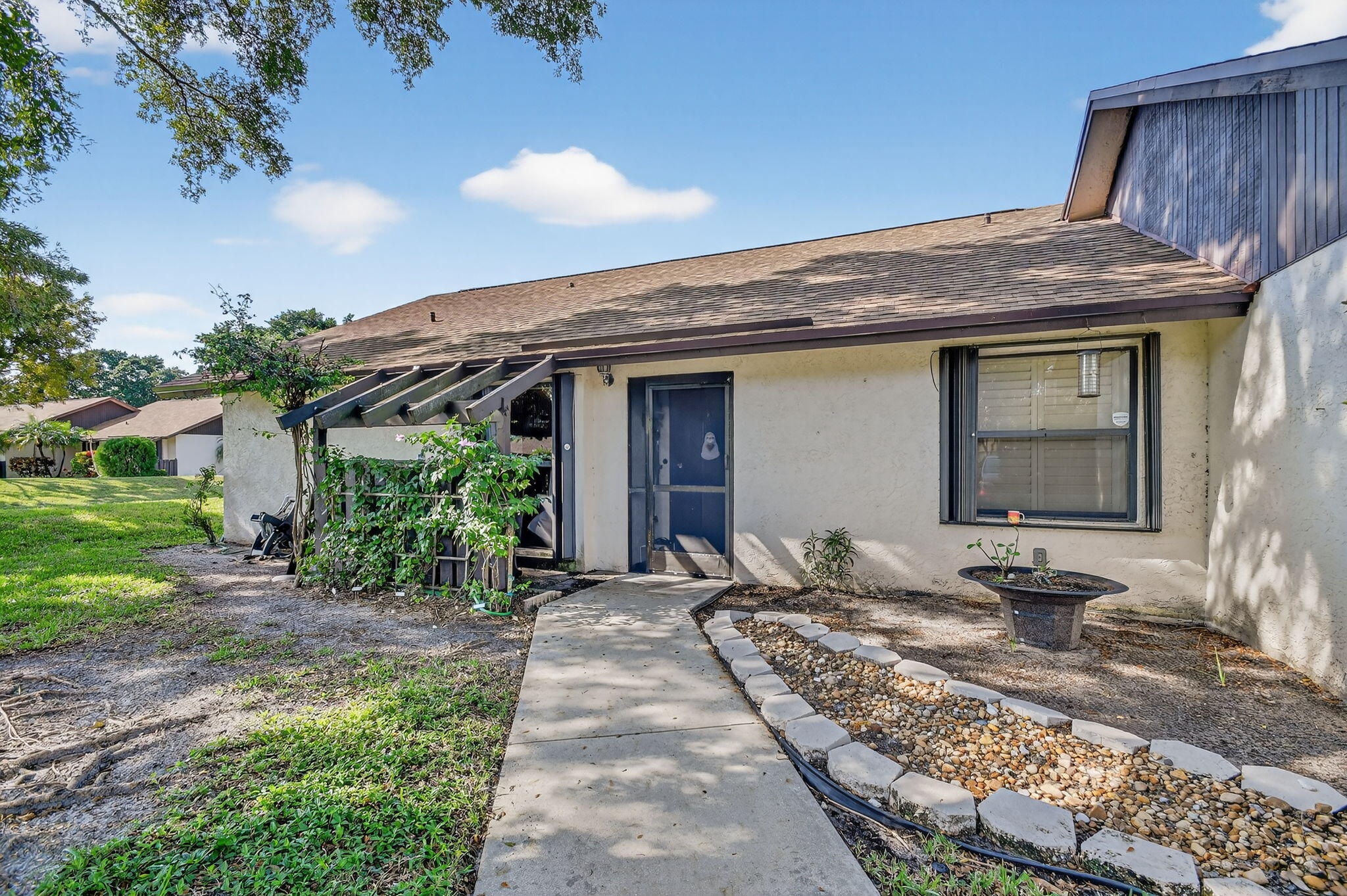 117 Vía De Casas Norte Boynton Beach, FL 33426 - Photo 1 of 31 a front view of a house with garden