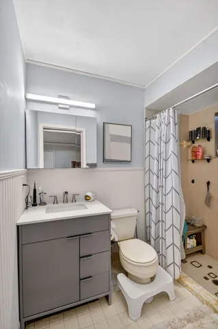 a bathroom with a toilet a sink and mirror