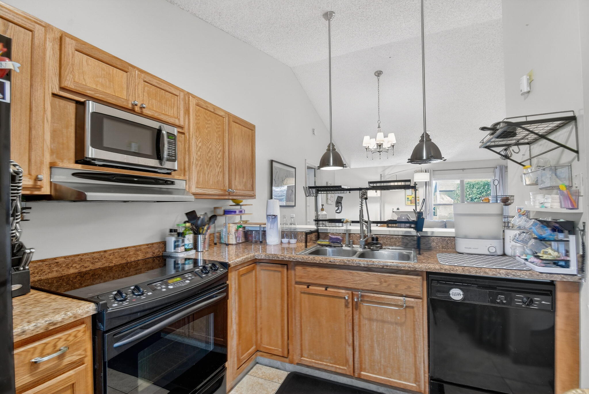 117 Vía De Casas Norte Boynton Beach, FL 33426 - Photo 6 of 31 a kitchen with stainless steel appliances granite countertop a stove a sink and a microwave