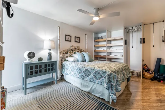 a bedroom with a large bed and a wooden floor