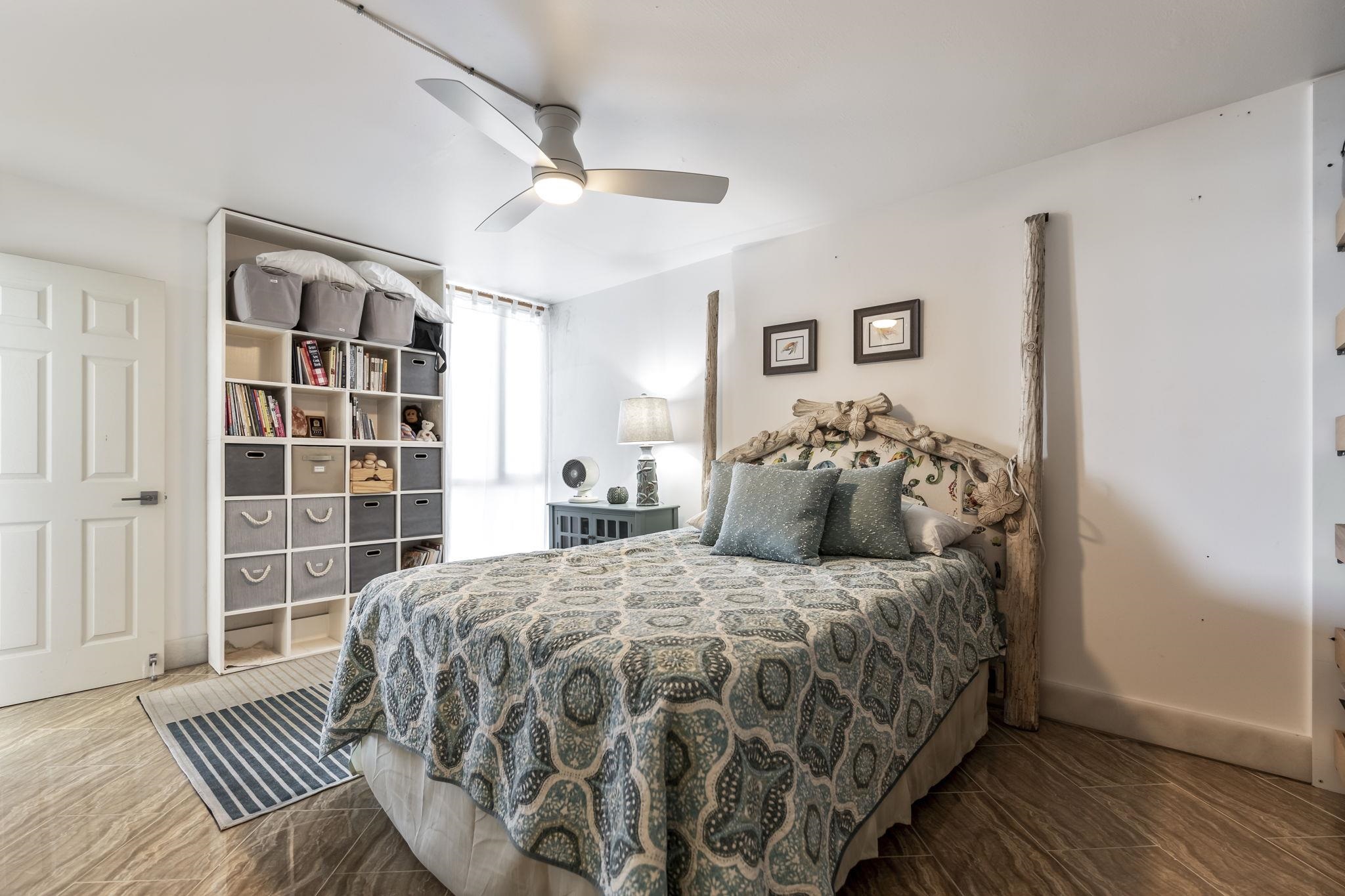 111 Kahului Beach Road, Unit A426 Kahului, HI 96732 - Photo 15 of 24 a bedroom with a large bed and a wooden floor