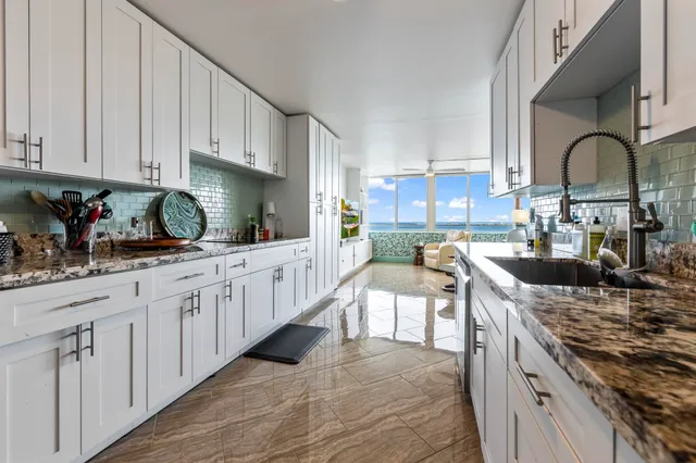 a kitchen with stainless steel appliances granite countertop a stove a sink dishwasher and cabinets with wooden floor