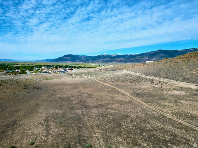 600 East E Street Moroni, UT 84646 - Photo 12 of 38 Expansive undeveloped land featuring natural desert vegetation, a visible dirt path, and a mountain range backdrop