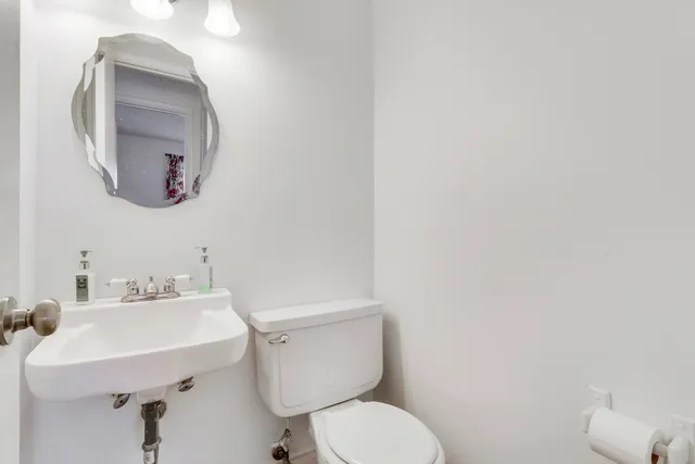 a bathroom with a toilet a sink and mirror