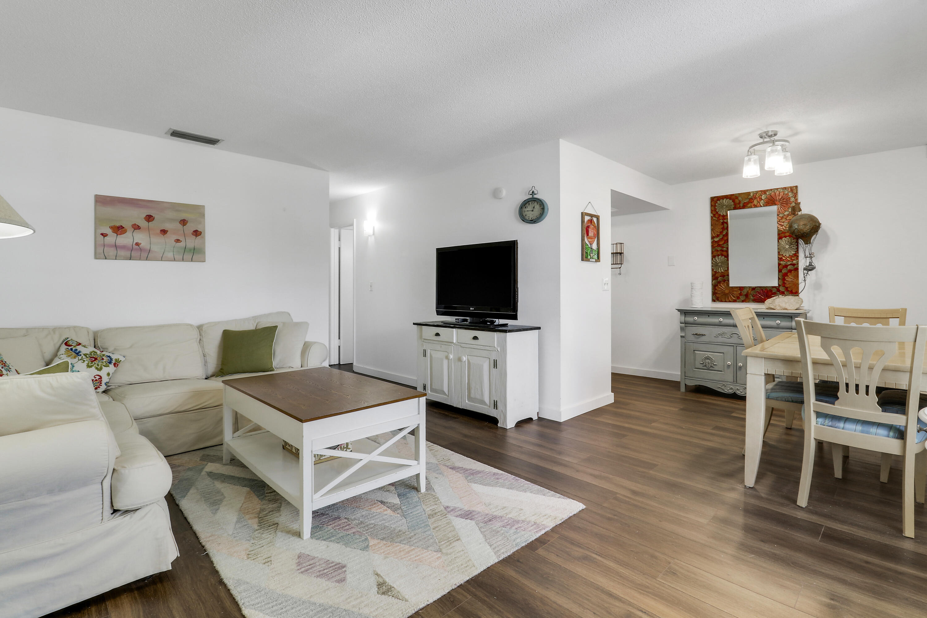 2929 Southeast Ocean Boulevard, Unit 19 Stuart, FL 34996 - Photo 3 of 19 a living room with furniture and a flat screen tv